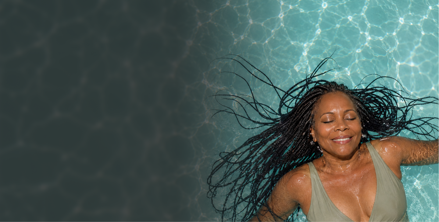 Angie floating in a pool with long jet black braids